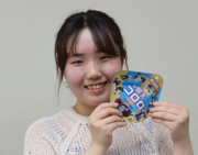 デザインした「関大コロロ」を手にする多田さん.png