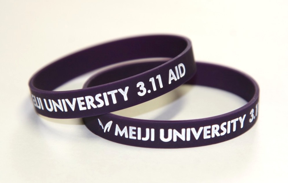 明治大学が東日本大震災復興支援リストバンド「Meiji University 3.11 AID」 を製作、学生に配布　～被災地支援の“輪”　広がりを願って～